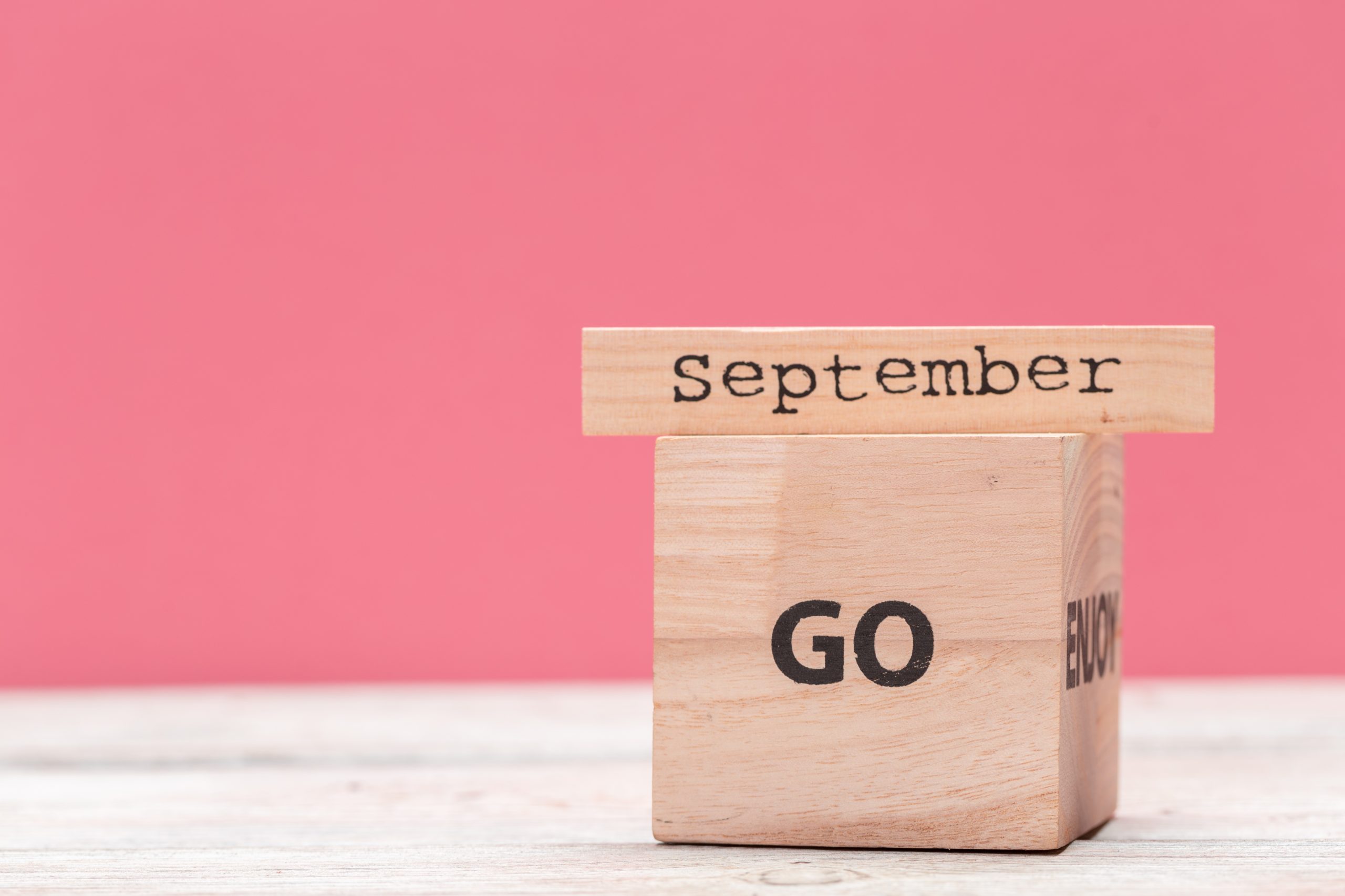 Wooden cubes with text on table over pink background with copy space for text